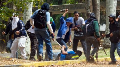 Un estudiante sufre una paliza en la Universidad Central de Caracas a manos de grupos pro gubernamentales.